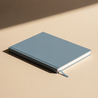 Blue notebook on a beige surface with a soft shadow